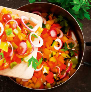 Chopped vegetables going into a pan